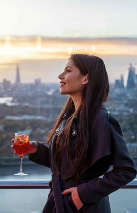 Urban,business,woman,relaxes,in,a,rooftop,bar,in,london